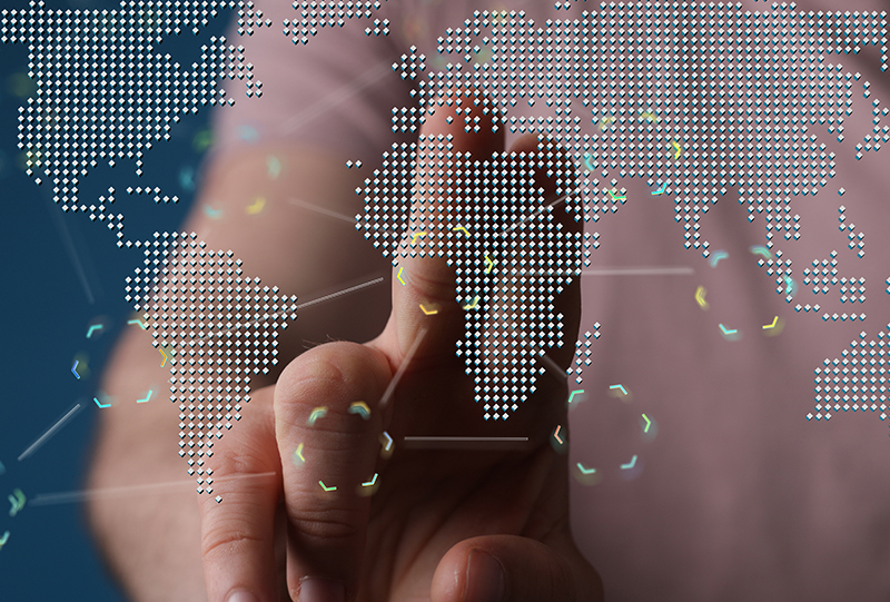 A person's hand reaching towards a glowing digital dotted world map, representing global real-world data and evidence.